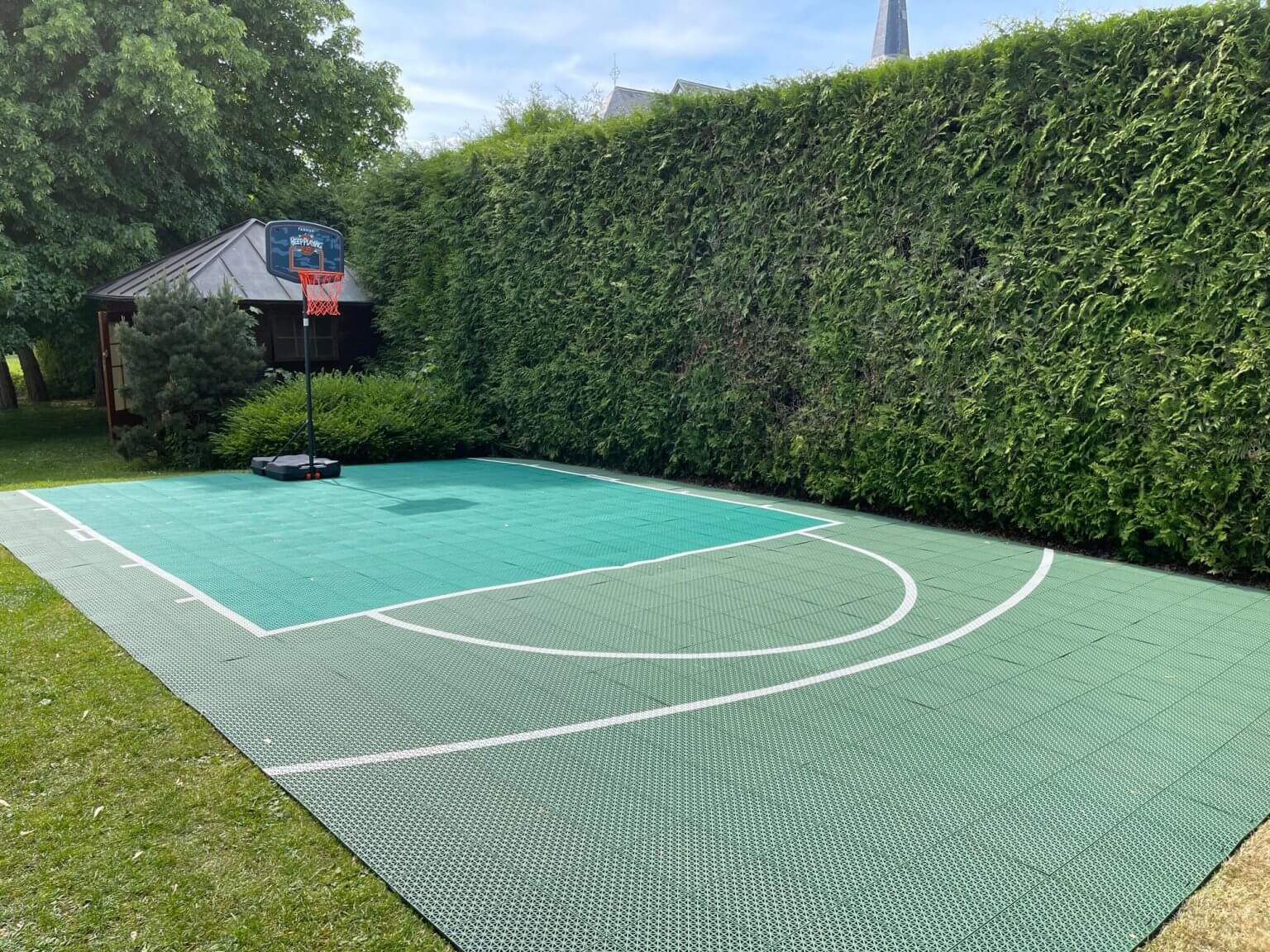 Installer un terrain de basket en dalles clipsables sur de l'herbe ou